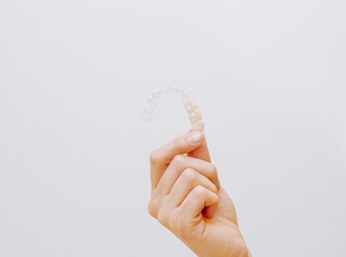 Close-up of a clear Invisalign aligner held in hand